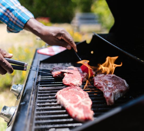 Man cooking on a gas grill.